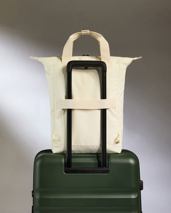 a white bag on a green suitcase