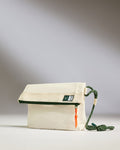 a white bag with a green strap