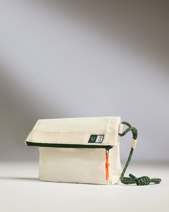 a white bag with a green strap