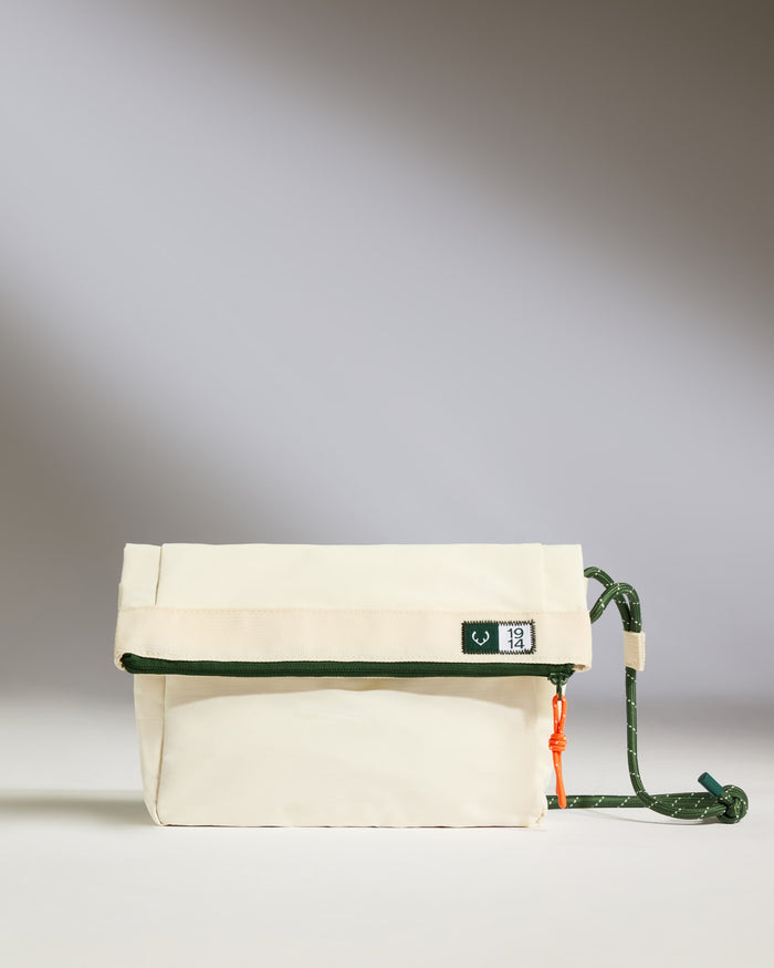a white bag with green straps