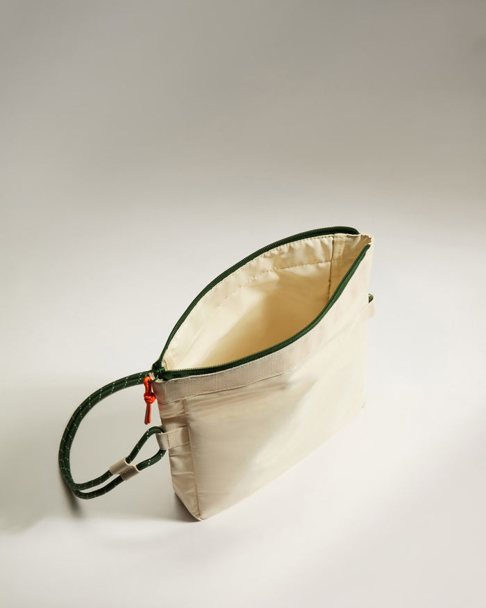 a white bag with green straps