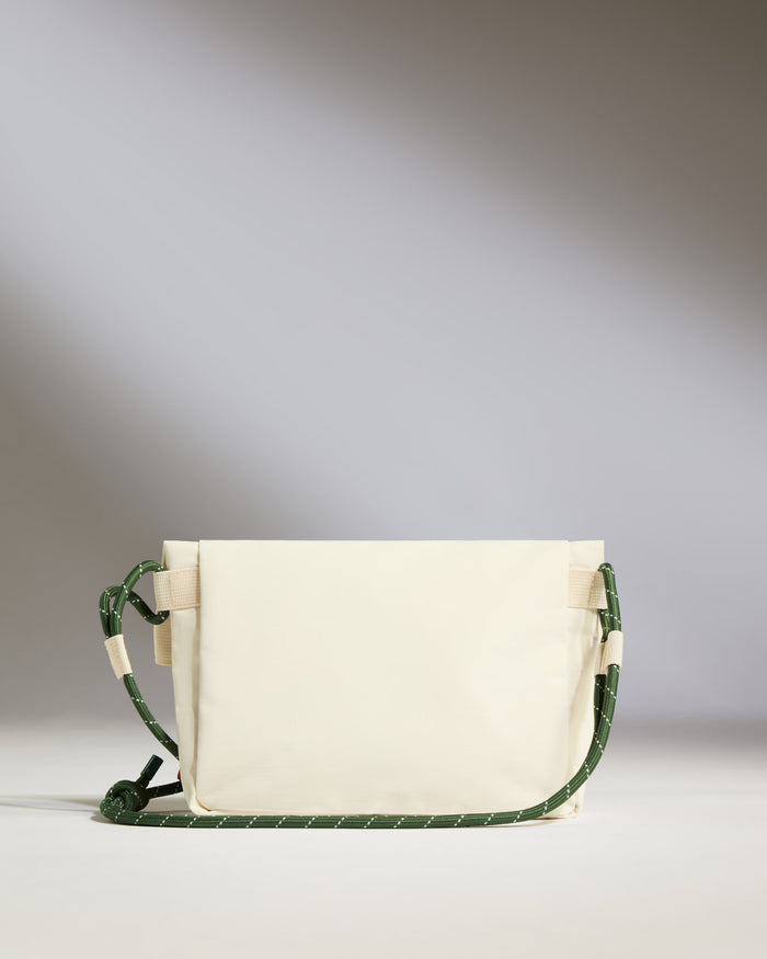 a white bag with green straps