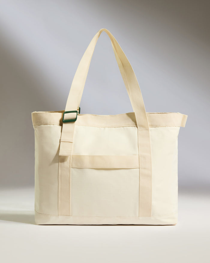 a white bag with a green strap