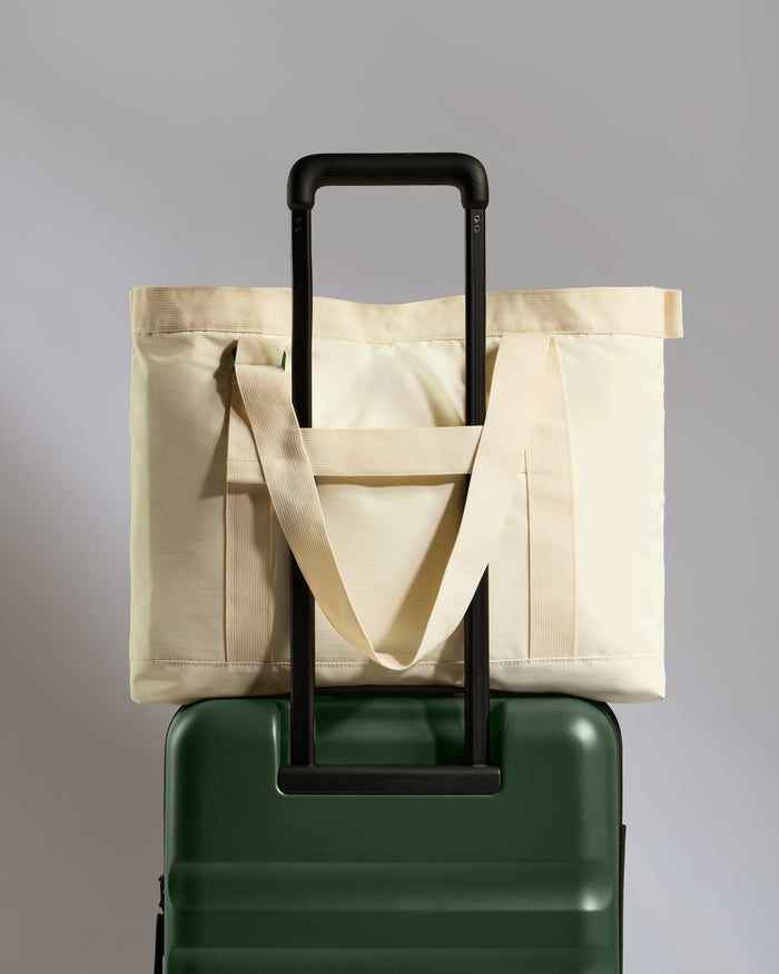 a green and white bag on top of a green suitcase