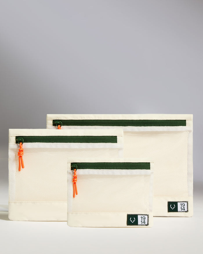 a group of white bags with green zippers