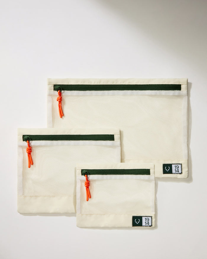 a group of white bags with red zippers