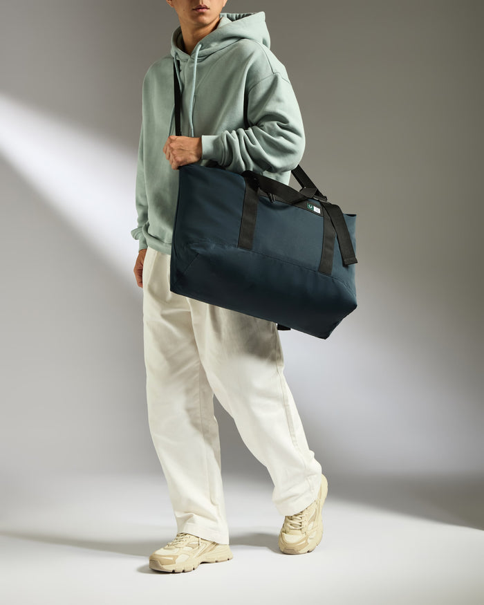 a man in a hoodie carrying a bag