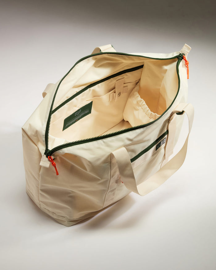 a white bag with green zippers