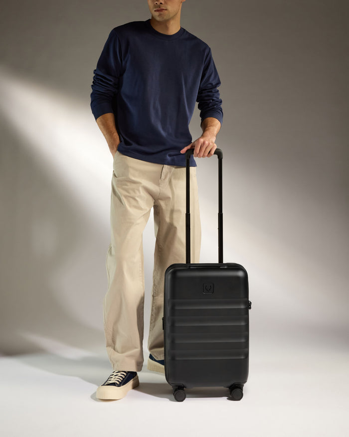 a man standing with his hand on a suitcase