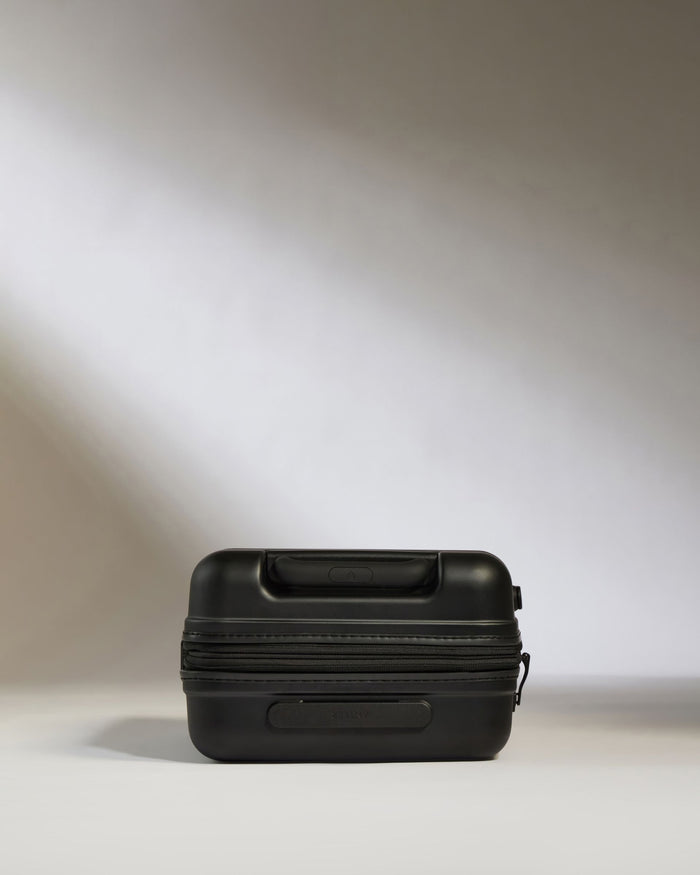 a black suitcase on a white surface