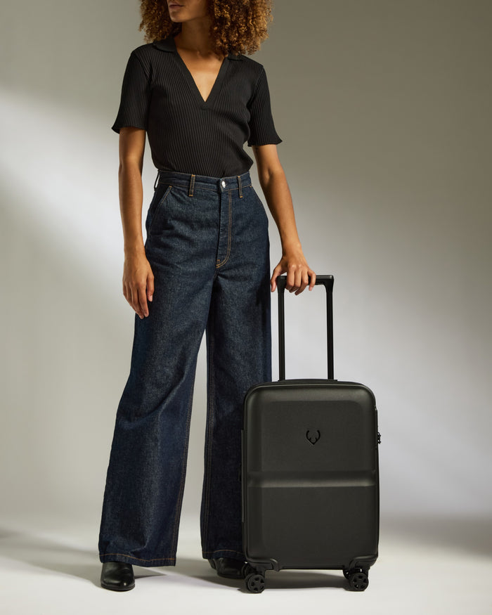a woman standing next to a suitcase