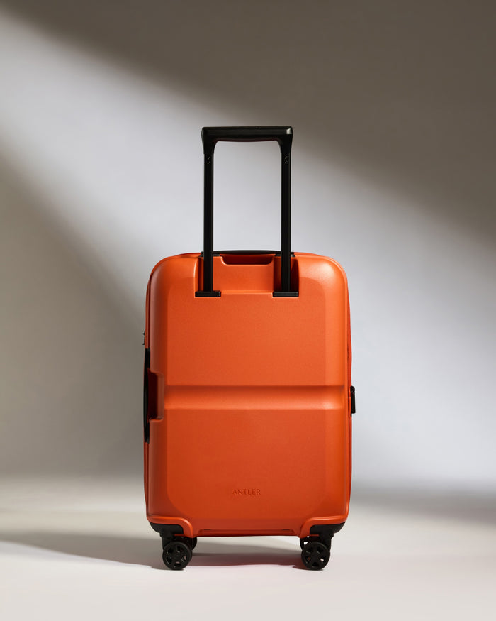 an orange suitcase with black wheels