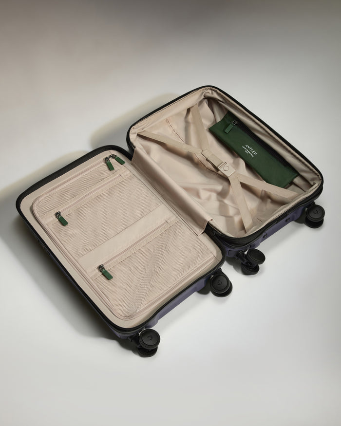 a suitcase with wheels and a green bag