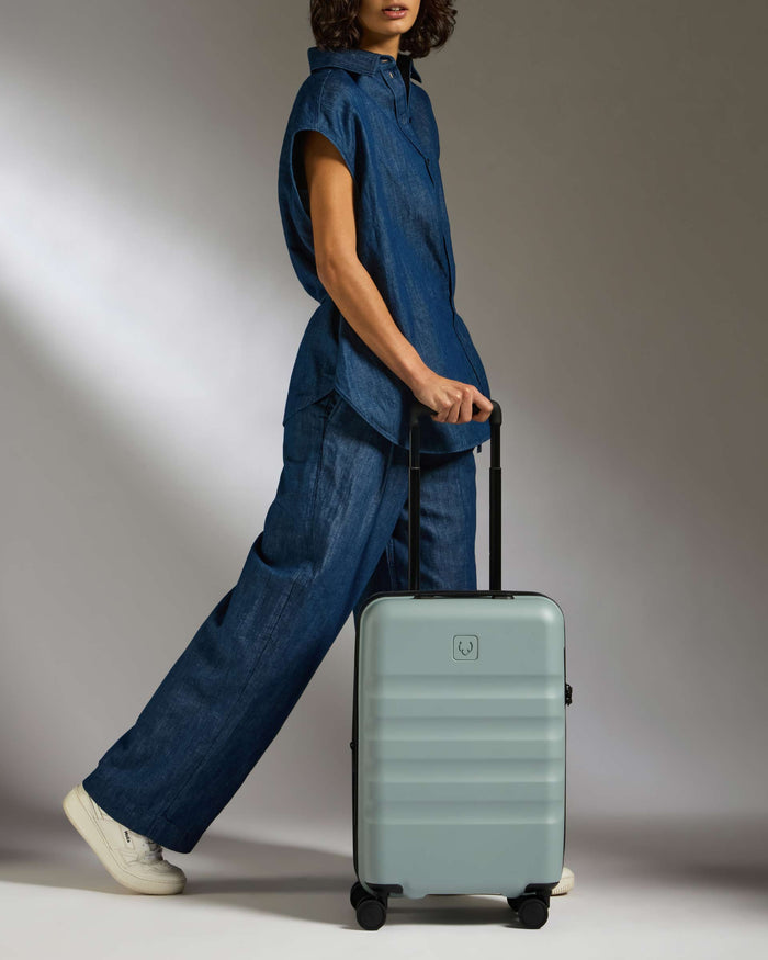 a woman in a blue outfit with a suitcase