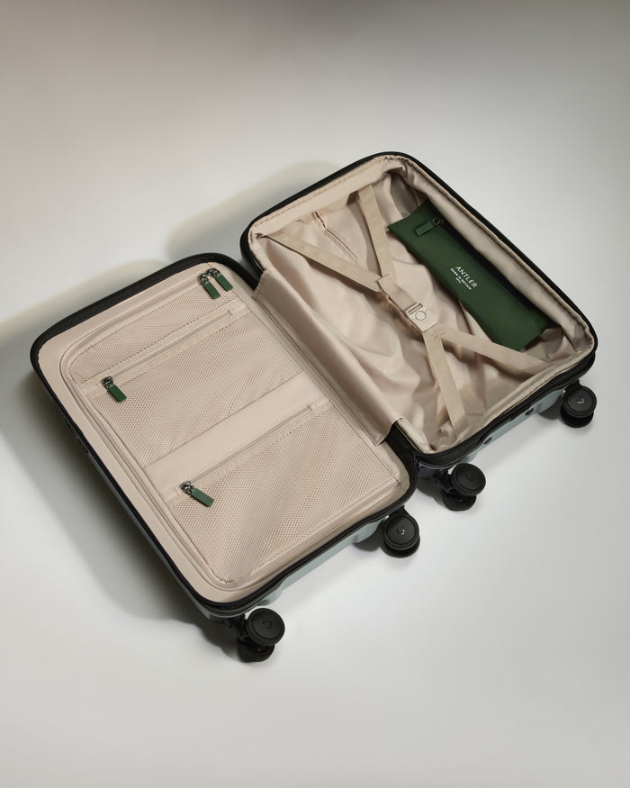 a suitcase with wheels and a green bag