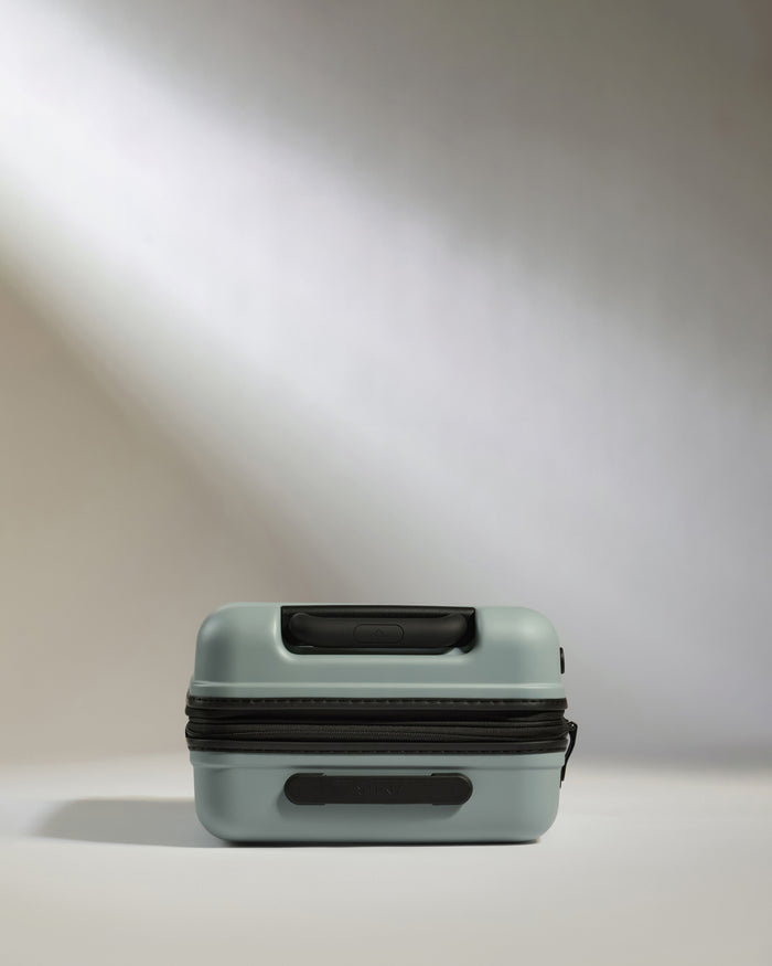 a small blue suitcase with black straps