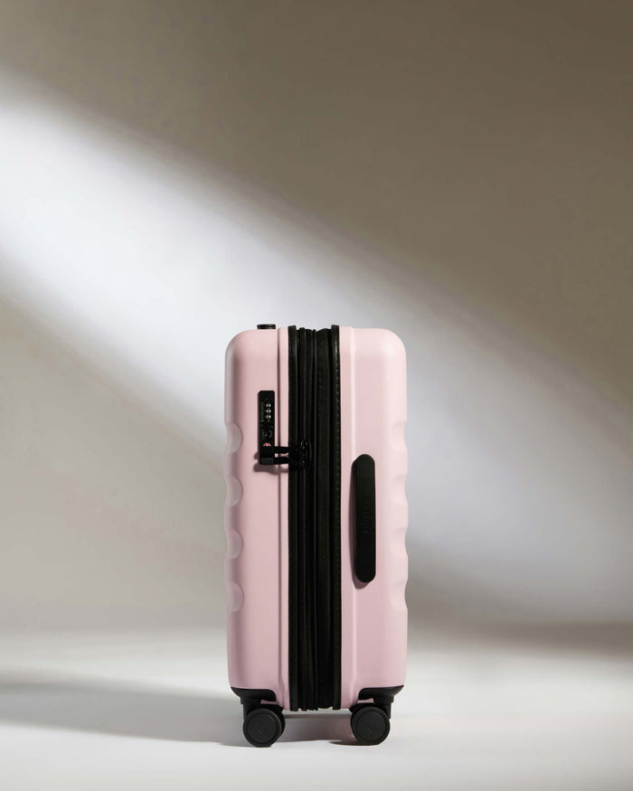 a pink suitcase with wheels