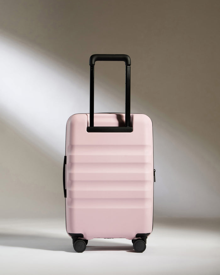 a pink suitcase with black wheels