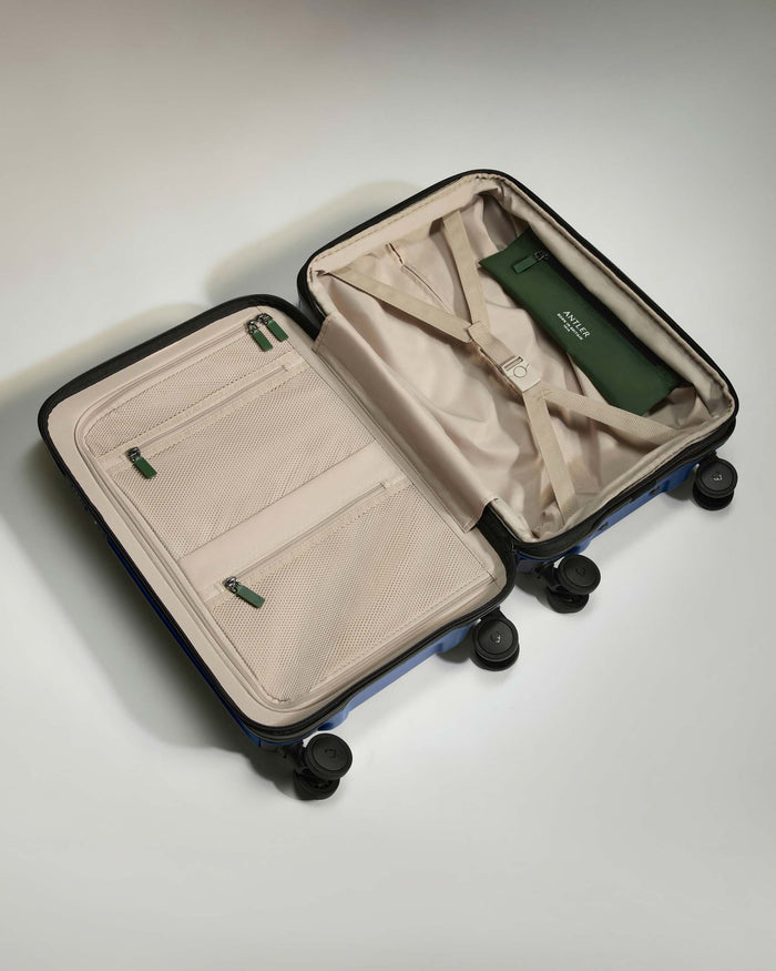 a suitcase with wheels and a green bag