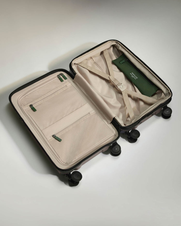 a suitcase with wheels and a green bag
