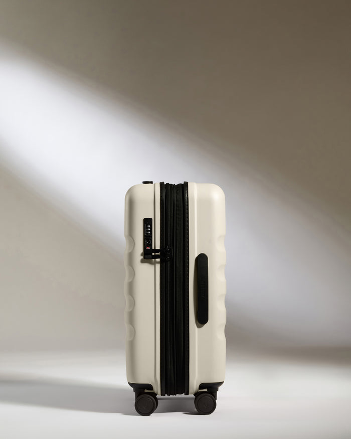 a white suitcase with black wheels