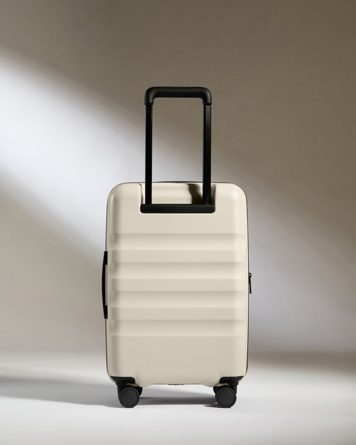a white suitcase with black handles