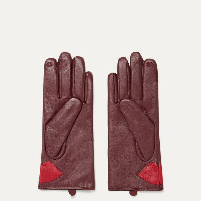 Burgundy leather gloves with red lips on a white background.