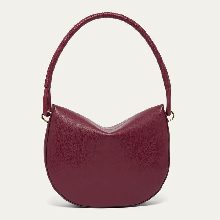 Burgundy leather shoulder bag with a corded handle on a light grey background