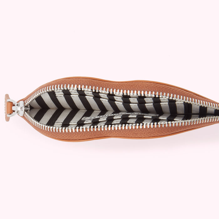 Tan leather pouch open to reveal a black and white striped interior.