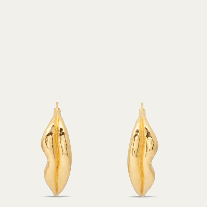A pair of gold lip-shaped hoop earrings with a textured finish, shown against a light gray background.