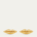 A pair of gold lips-shaped stud earrings on a light cream background.