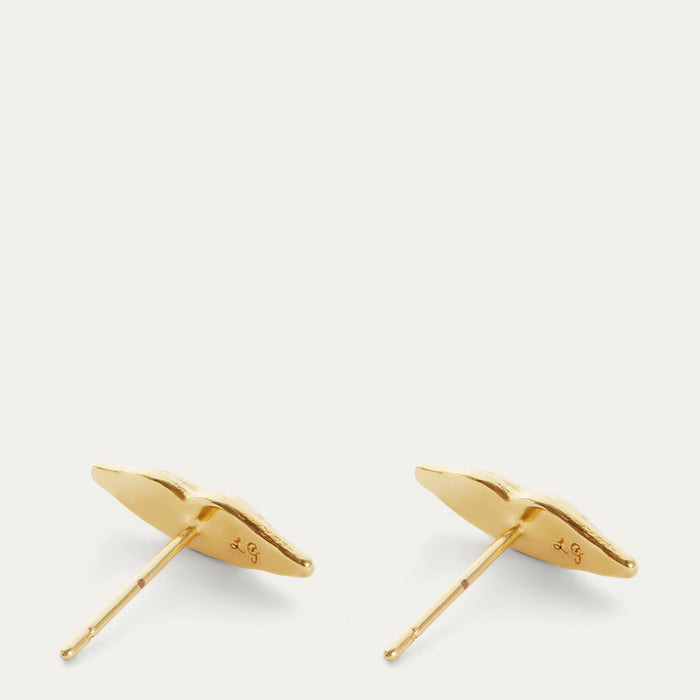 A pair of gold leaf stud earrings with post backs, shown from the side on a light off-white background.