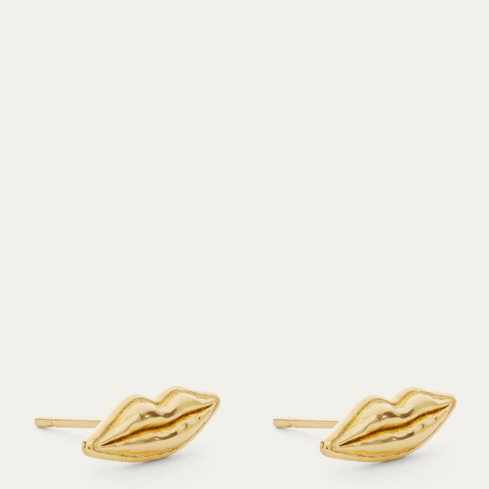 A pair of gold stud earrings shaped like lips, shown on a plain off-white background.