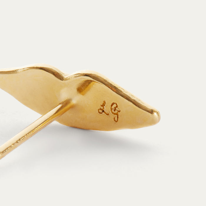 Close-up of a gold stud earring with a polished curved end and a post, showing an engraved 'LG' monogram on a clean white background.