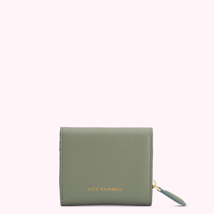 Sage green Lulu Guinness trifold wallet with gold zipper and logo.
