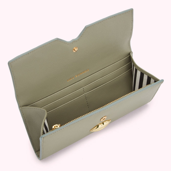 Sage green leather wallet open to reveal interior compartments and gold lip-shaped clasp.