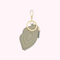 Sage green lip-shaped zipper pouch keychain with gold-toned hardware.