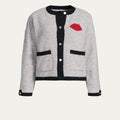Gray cardigan with black accents and a red lip print on a white background
