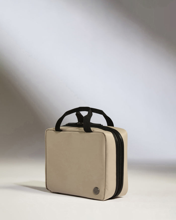 a small beige bag with black handles