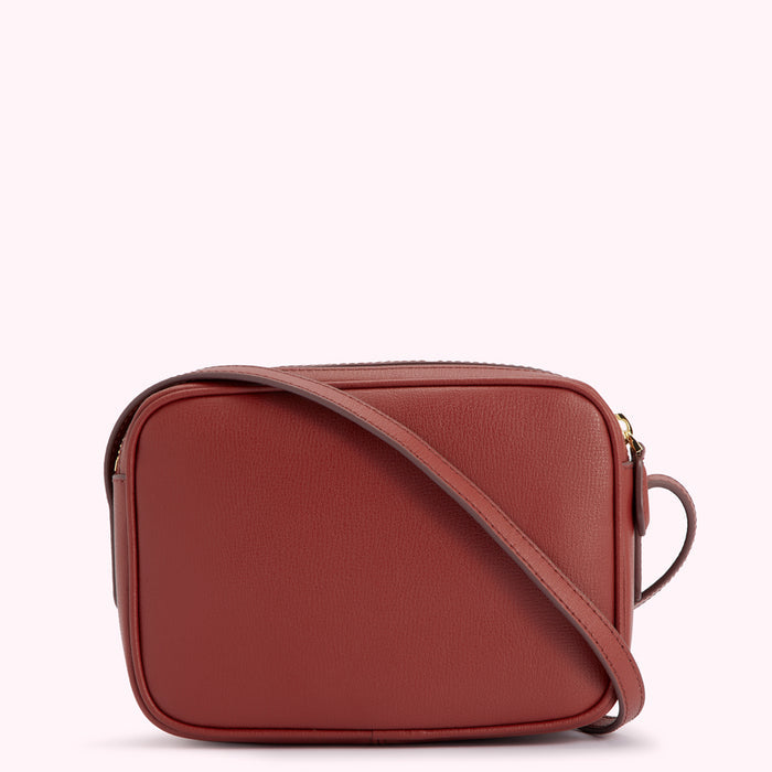 A burnt-orange leather crossbody bag with a gold zipper.