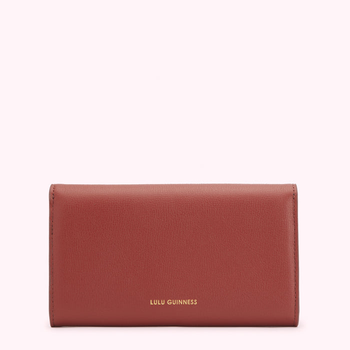 A red leather Lulu Guinness wallet on a white background.