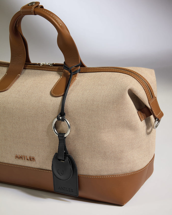 a brown and tan bag with a black tag