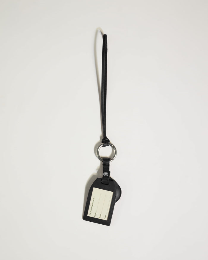 a black leather keychain with a white and black tag
