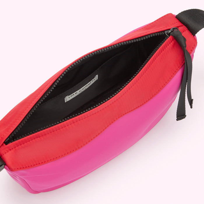 Interior of a bright pink, red and black Lulu Guinness nylon shoulder bag.