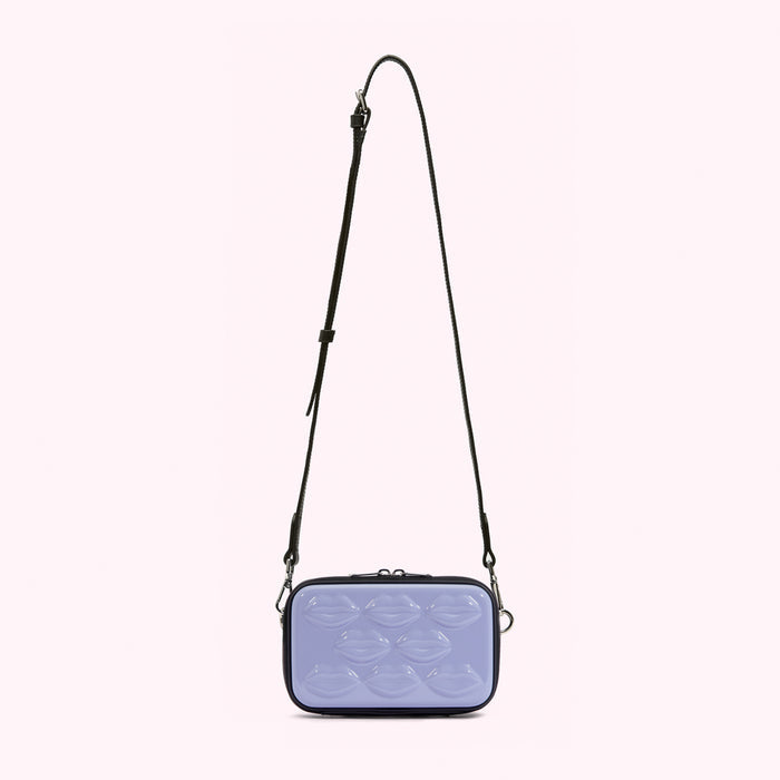 Lavender crossbody bag with black straps and lip-shaped detailing.