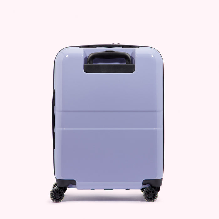Lavender-coloured suitcase with black handle and wheels, viewed from behind against a white background.