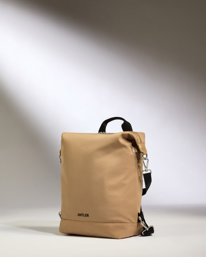 a tan backpack with black straps