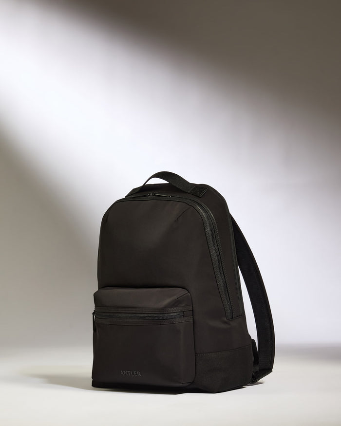 a black backpack on a white surface