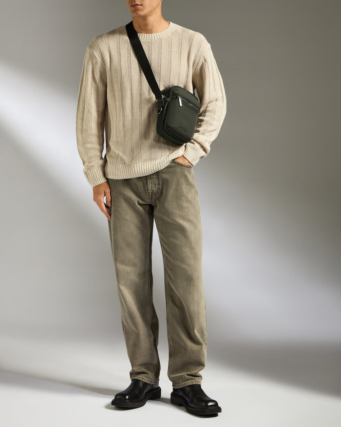 a man standing with a bag over his shoulder