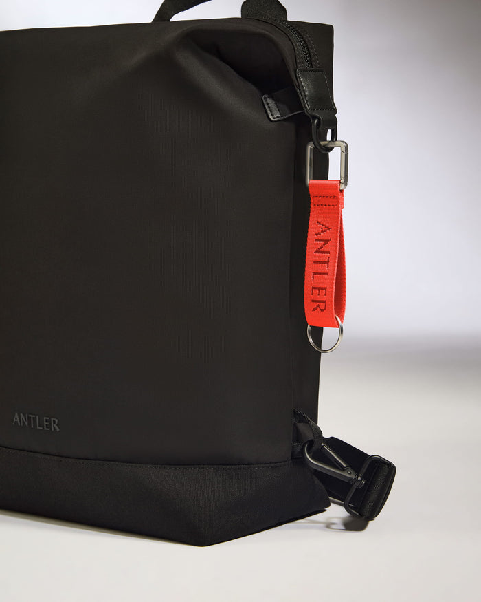 a black bag with a red strap